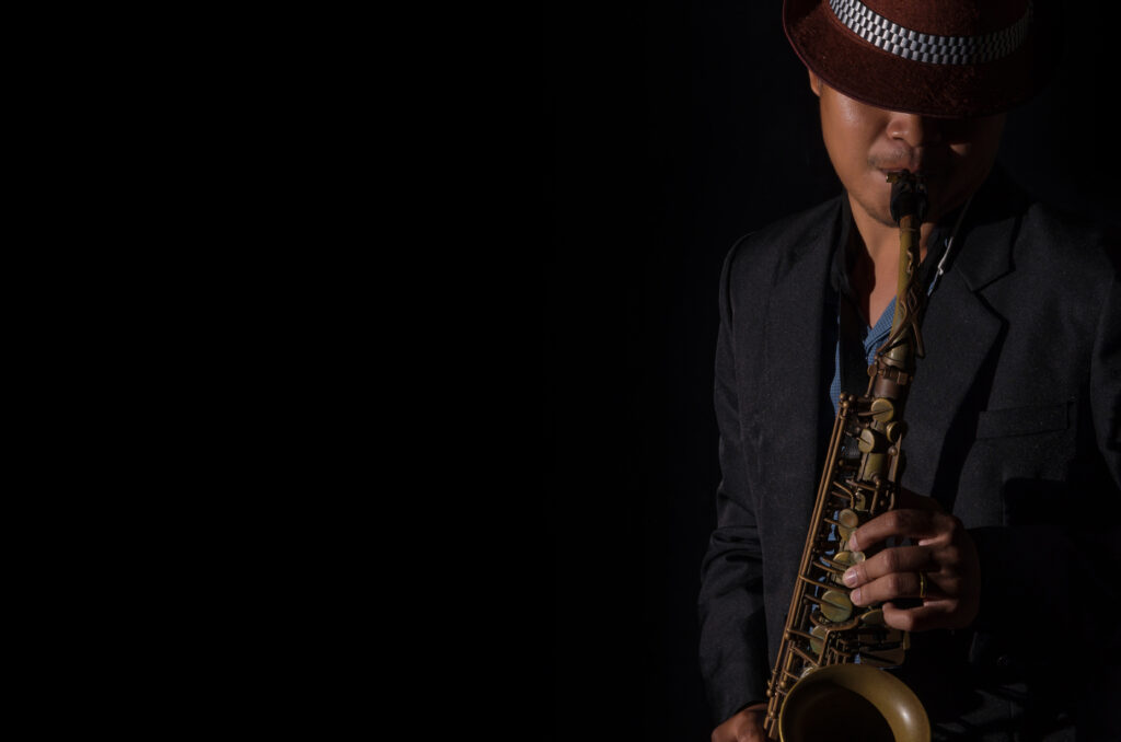 A saxophone player in a dark background